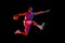 Athletic teen boy training, playing basketball against black studio background in neon light. Competitive spirit