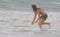 Athletic teen girl throwing a board into the ocean