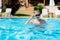 athletic teenager adjusts his swimming goggles while standing in a swimming pool