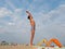 Athletic teenager on the beach gymnastic exercises