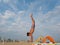 Athletic teenager on the beach gymnastic exercises