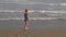 Athletic teenager on the beach in jump on the background of the sea and sky