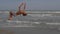 Athletic teenager on the beach in jump on the background of the sea and sky