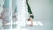 Athletic woman approaches the white wall and doing a handstand. Balance and sport, fitness lifestyle. The camera