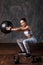 Athletic woman doing exercise with med ball. Photo of sporty latin woman in fashionable sportswear on black background