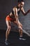 Athletic woman doing some cross fit exercises with battle rope indoor