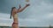 Athletic woman dressed sporty bikini is playing beach volleyball, medium portrait at nature, striking ball