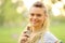 Athletic woman eating a protein bar - Closeup portrait of smiling young sporty girl posing while resting