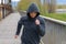 Athletic woman in a hoodie jogging across a bridge