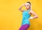 Athletic woman posing and looking to side, isolated on yellow background. Half length of sportswoman ready for exercising. Athlete