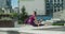 Athletic woman sits on a twine and stretches in the yard of an apartment building, fitness in the urban environment