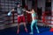 Athletic woman in sportswear and in boxing gloves training with