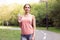 Athletic woman standing running track in summer park drink water after running exercises