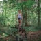 Athletic woman in a tank top and shorts in a forest among green trees