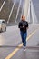 Athletic woman warms up on countryside bridge, jogging. Healthy lifestyle concept