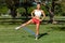 Athletic woman workout with resistance band outdoors. Fitness girl doing exercise for legs at the park