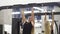 Athletic young blond female training on horizontal bar in black sportswear in gym performing pulls-up