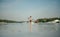 Athletic young man paddles on a sup board on the river on a sunny weekend. Muscular man trains rowing on sup board