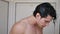 Athletic young man taking shower on the beach