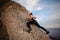 Athletic young pretty girl rock climbing without carbines and rope, bouldering.