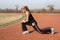 Athletic Young Woman Stretching at the Track