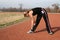 Athletic Young Woman Stretching at the Track