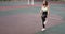 Athletic young woman is training doing lunges on sport stadium ground in campus.