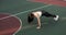 Athletic young woman is training doing push-ups on stadium in College campus.