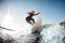 Athletic young woman in wetsuit stands on surfboard and rides on the wave.