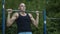 Athletically built man pulls up on the horizontal bar. Loads on different types of muscles. Bodybuilding. Outdoor sports