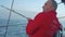 ATLANTIC - CIRCA NOVEMBER 2017: Close up view of yachtsman in red coat pulling fishing pole from water and other members