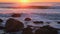 Atlantic ocean sunset with waves and rocks at Costa da Caparica, Portugal