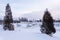 Atlantic tomcod ice fishing cabins on a frozen river with a bridge and church in the background,