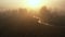 Atmospheric aerial flyover, amazing foggy valley, trees and river covered with thick mist on epic warm summer sunrise.