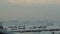 Atmospheric aerial timelapse of cargo ships and boats waiting in line at shipping dock in beautiful sea background.