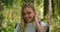 Atmospheric close-up portrait of young beautiful smiling girl in hat with flying hair at forest slow motion