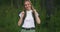 Atmospheric close-up portrait of young beautiful smiling girl in hat with flying hair at forest slow motion