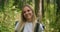 Atmospheric close-up portrait of young beautiful smiling girl in hat with flying hair at forest slow motion