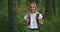 Atmospheric close-up portrait of young beautiful smiling girl in hat with flying hair at forest slow motion