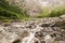 Atmospheric landscape with big stones in mountain river. Powerful water stream among boulders in mountain creek