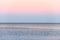 Atmospheric romantic pink red sea sunset sky above blue quiet water, minimalistic peaceful seascape