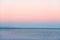 Atmospheric romantic pink red sea sunset sky above blue quiet water, minimalistic peaceful seascape