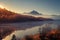 Atmospheric sunrise over an alpine forest reflected in a still lake