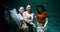 Atmospheric underwater portrait, three young attractive happy women posing in boho clothes, rising up slow motion.