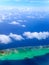 The atoll in ocean through clouds. Aerial view.Landscape in a sunny day