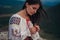 Atractive woman in traditional romanian costume on mountain green blurred background. Outdoor photo. Traditions and cultural