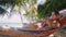 Atractive young happy woman Using Mobile Phone in Hammock at the Beach near the Sea and palm tree. Thailand. HD. Slow