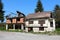 Attached family houses destroyed in war abandoned by owners with missing windows and broken roof surrounded with uncut grass and