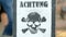 attention - mines! skeleton sign closeup. warning message on german language on wooden surface