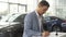 An attentive buyer signs a contract for the purchase of a car